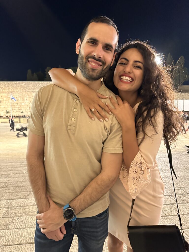 A man and a woman, smiling at the Western Wall
