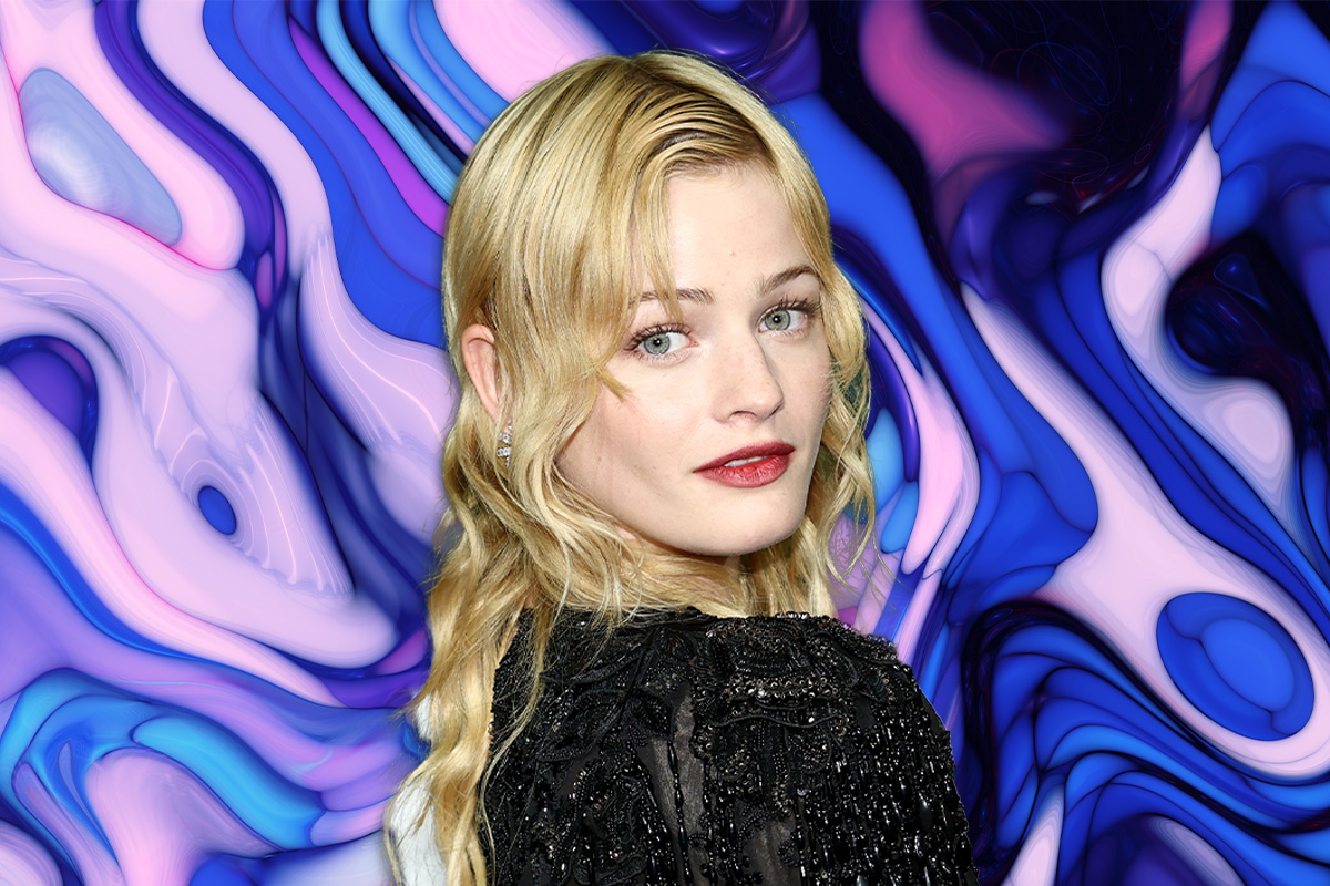 A photo of a young blonde woman looking over her shoulder on a purple and blue background