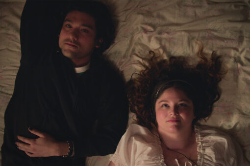 A man and a woman lie on a bed and stare at the ceiling.