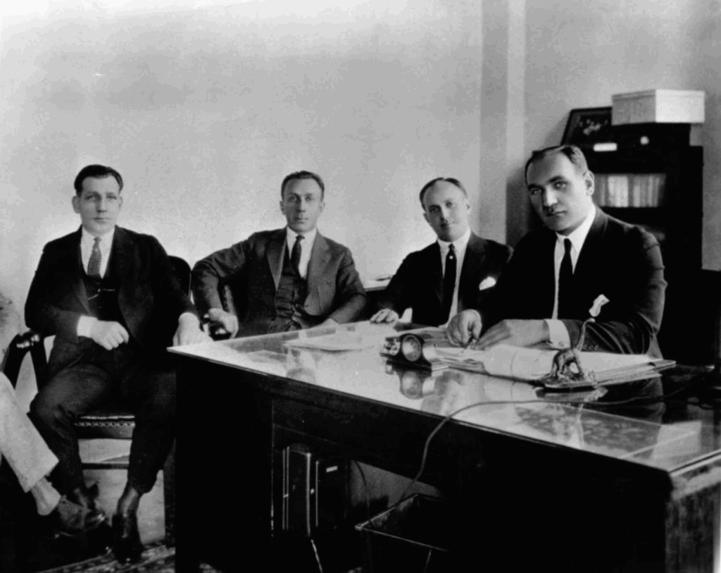 Harry, Albert, Sam and Jack Warner sit at a table.