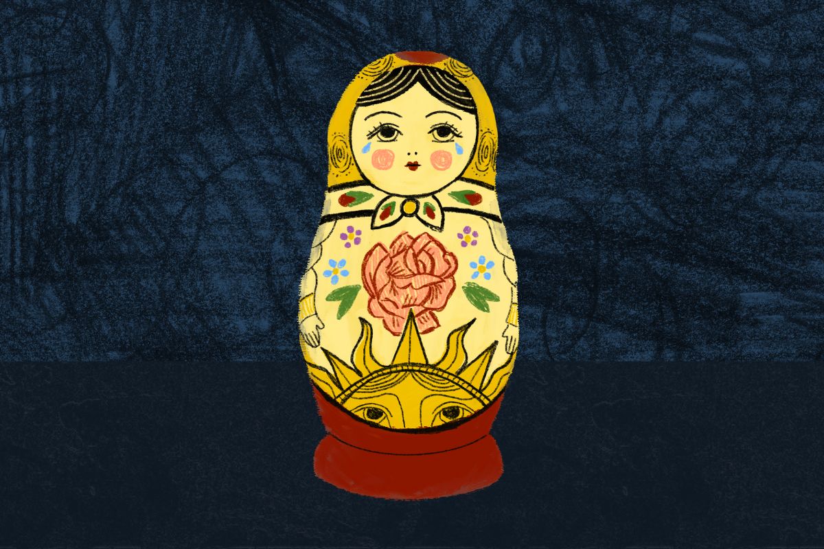 A yellow Russian nesting doll or matryoshka doll stands against a navy blue background. The doll is yellow with red, green and blue accents.