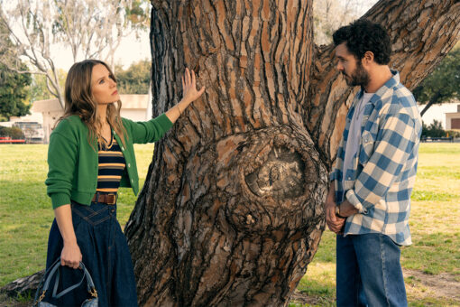 Kristen Bell and Adam Brody stand by a tree in a still from "Nobody Wants This."
