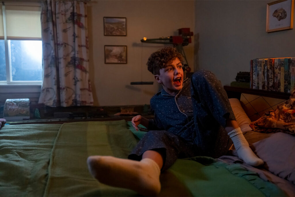 A young boy screams on his bed in "IT: Welcome to Derry."