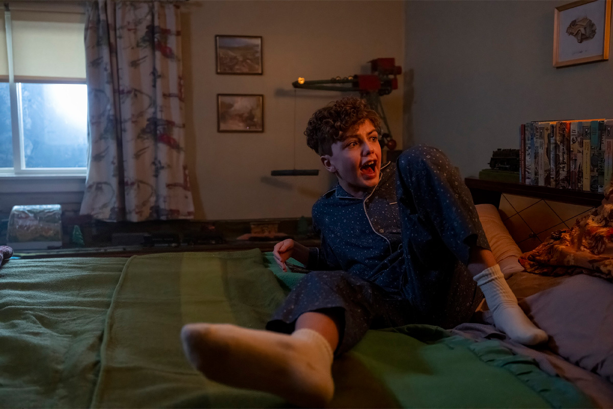 A young boy screams on his bed in "IT: Welcome to Derry."