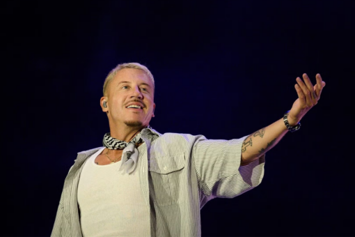Macklemore performing onstage wearing a keffiyeh